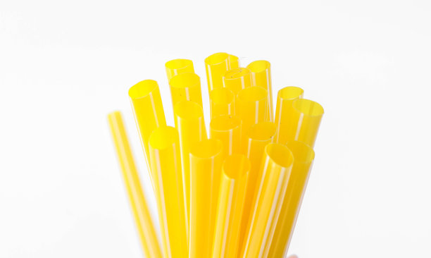 彩色的一排塑料吸管被隔离在白色的背景和空白的空间。秸秆洞的深场照片图片下载