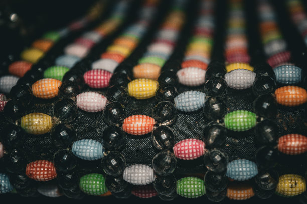 五颜六色的浆果珠系在一个女士的包上图片下载