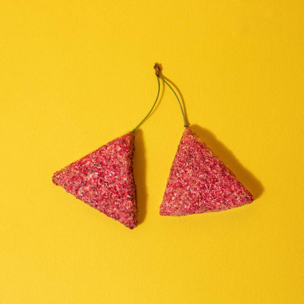 粉红色的饼干，黄色背景上的茎像樱桃。创意理念图片下载