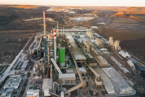 鸟瞰图广阔的领土，大型工业钢铁工厂与高管道在明亮的冬季夕阳。环境污染。浓烟从高高的管子里冒出来。无人机图片下载