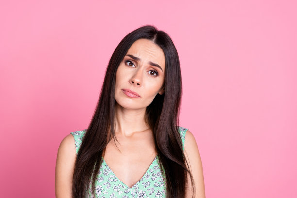 悲伤的照片，可爱的魅力女人穿着时髦的衣服，坏心情孤立在粉红色的背景图片下载