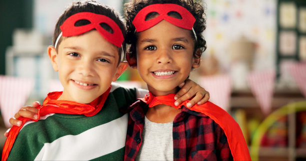 快乐的男孩，照片和朋友拥抱在服装cosplay，万圣节或打扮在学校。孩子们带着微笑，穿着超级英雄的衣服，在教室里寻找伙伴、友谊或支持图片下载