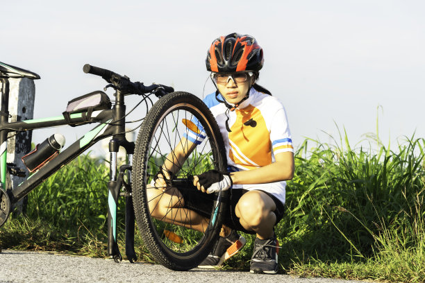 一个骑自行车的人在天空的背景下修理自行车图片下载