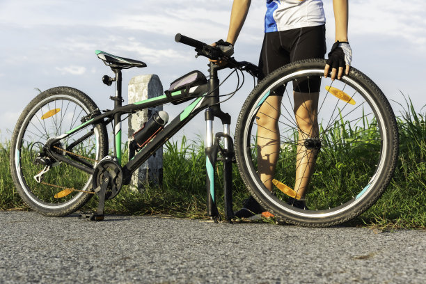 一个骑自行车的人在天空的背景下修理自行车图片下载