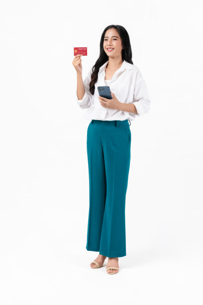 美丽的亚洲女人拿着信用卡，用白色背景的智能手机。图片下载
