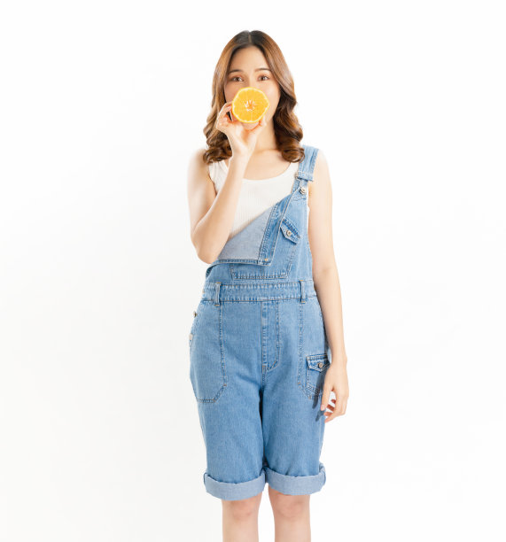 迷人的快乐的女孩拿着多汁的橙子在白色的背景，维生素健康的皮肤。图片下载