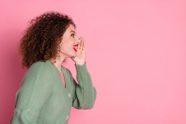 侧面照片开朗积极可爱的女人穿着时尚的衣服，在粉红色的背景上看起来空间空旷孤立图片下载