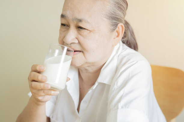 亚洲老年成熟的妇女饮用牛奶为补钙食品，有益健康。图片下载