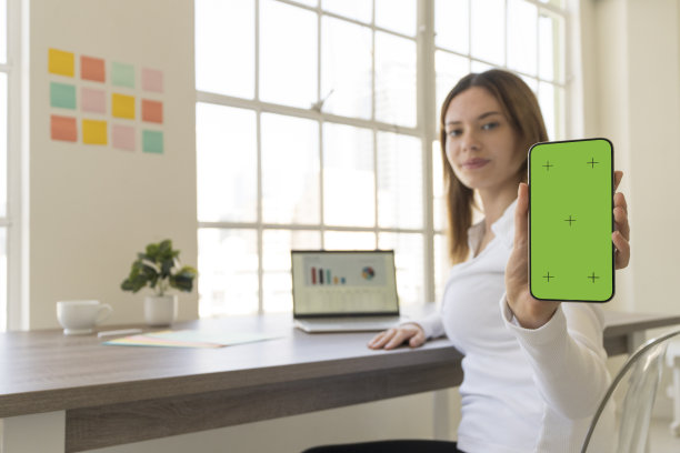 一名女子在城市阁楼里一扇明亮的大窗户旁工作图片下载