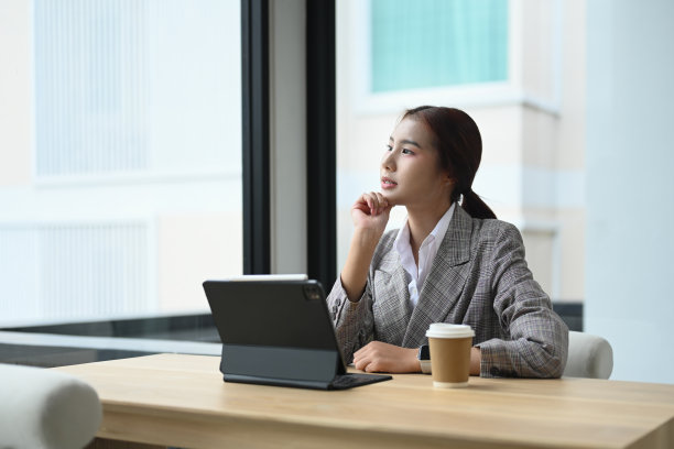 照片中，一位迷人的女商人抚摸着下巴，目光移开，思考着问题或想法。图片下载