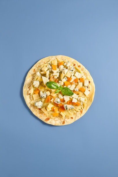 大饼与四个奶酪在蓝色背景-美味的美食披萨股票照片图片下载