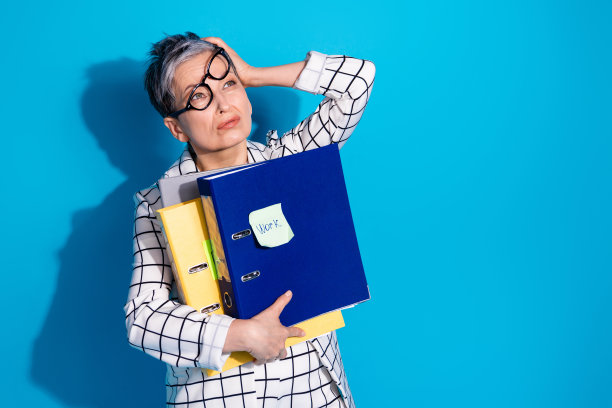 照片中，疲惫无聊的成功女性穿着白色时尚的衣服，拿着文件，在蓝色的背景上看起来空无一物图片下载