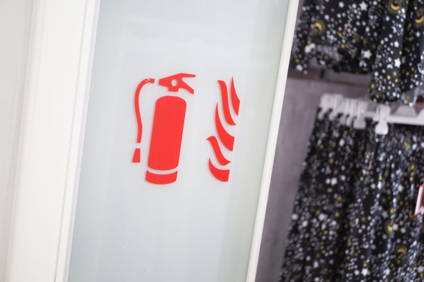 商店过道上有一个标志，表明灭火器和消防水管的存在图片下载