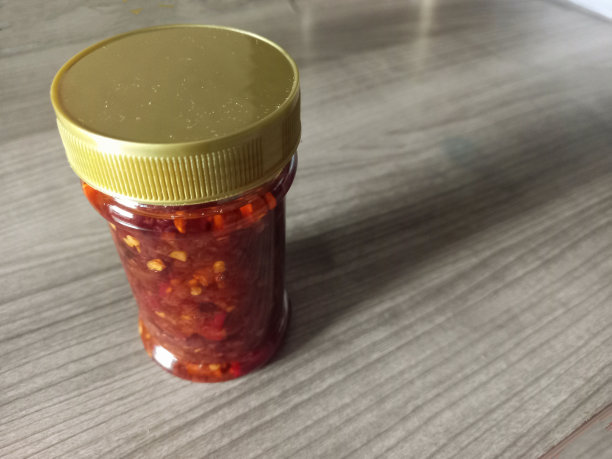 木桌上放着透明包装的辣椒酱图片下载