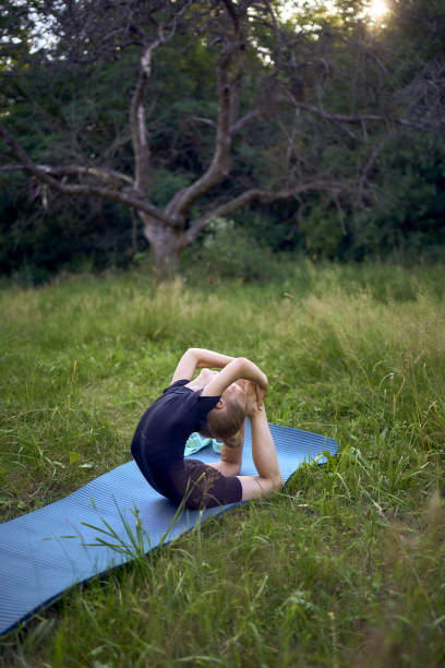 一个5岁的小女孩穿着黑色的极简主义连衣裤在室外的花园里做体操图片下载