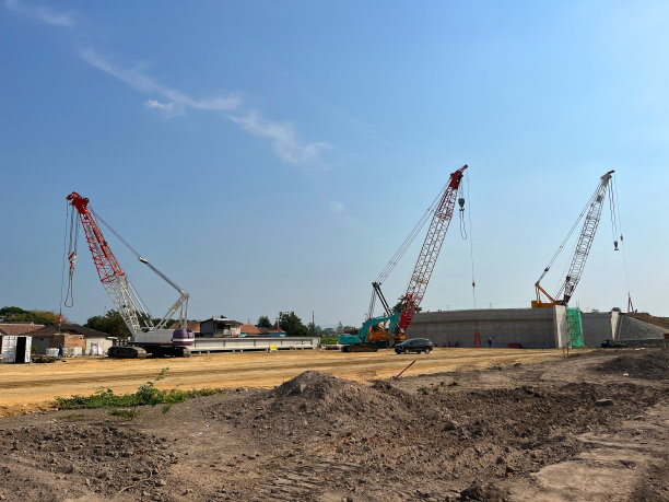 履带式起重机。大型建筑工地的柴油电动黄色履带起重机，包括在建筑综合体上工作的几台起重机;图片下载