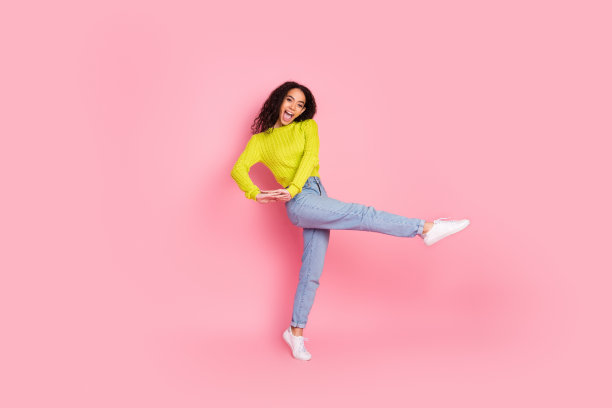 照片肖像十几岁的女孩黑发卷头发有乐趣跳舞时，冬季销售开始孤立的粉红色背景图片下载