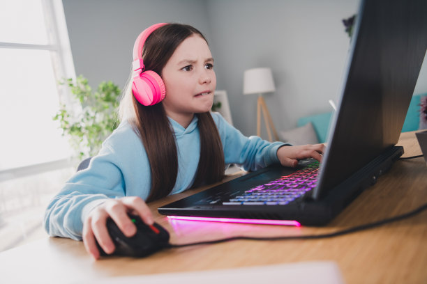 可爱可爱的女孩在室内玩网络视频电脑游戏的照片图片下载