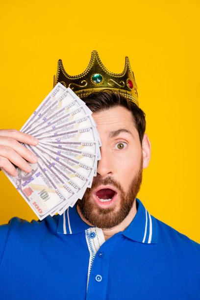 垂直照片帅气的年轻人惊讶封面脸钱王穿着时尚的蓝色服装孤立在黄色的背景图片下载