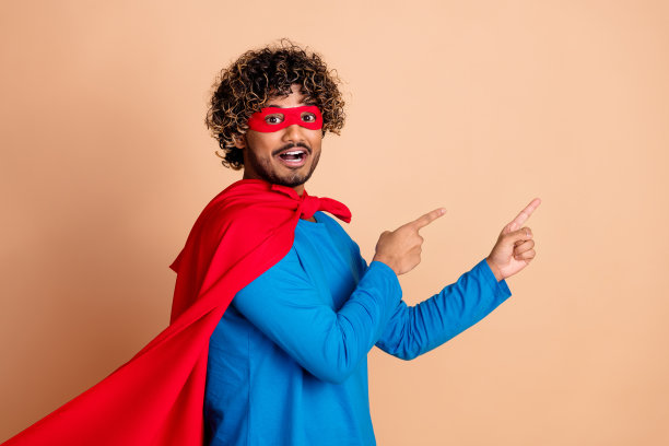 照片的有趣的积极的人穿着服装幻想卡通英雄红色面具空的空间孤立的米色背景图片下载