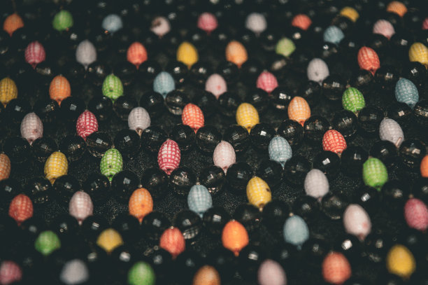 五颜六色的浆果珠系在一个女士的包上图片下载