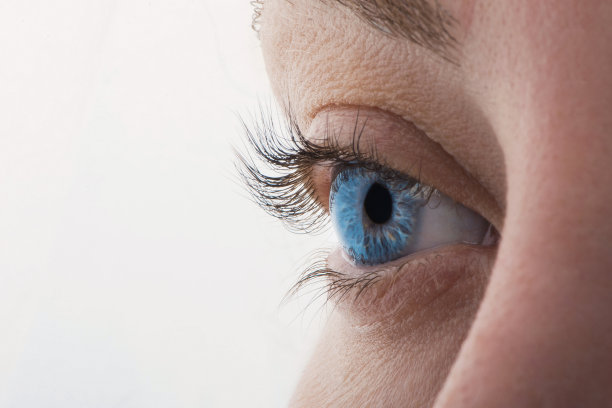 美丽的蓝色女性眼睛直视镜头的微距照片。合上年轻女子的眼睛。图片下载