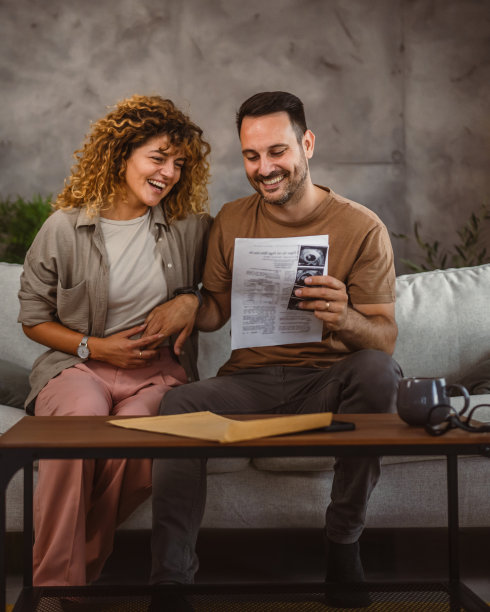 一对夫妇看着超声波图片，阅读婴儿的医疗记录图片下载