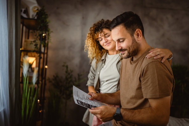 妻子抱着丈夫看孩子的超声波照片图片下载