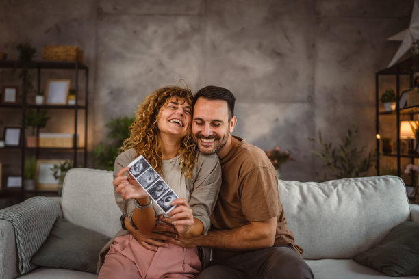 夫妻俩坐在一起，抱着婴儿的超声波照片图片下载