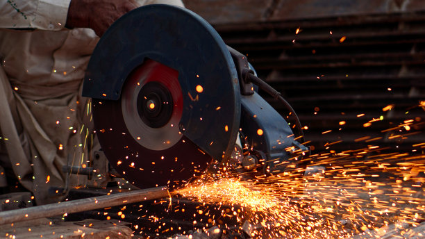 焊工在车间用电动切割器切割管道，引起火焰和火花图片下载