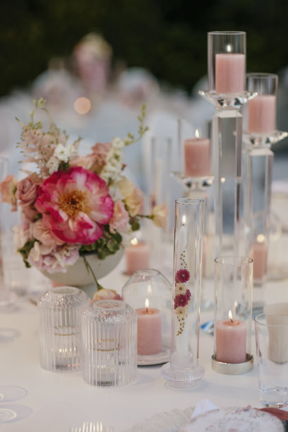 在为婚礼晚宴准备的桌子上，五颜六色的鲜花插在小玻璃瓶里。库存图片图片下载