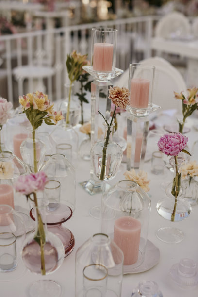 在为婚礼晚宴准备的桌子上，五颜六色的鲜花插在小玻璃瓶里。库存图片图片下载
