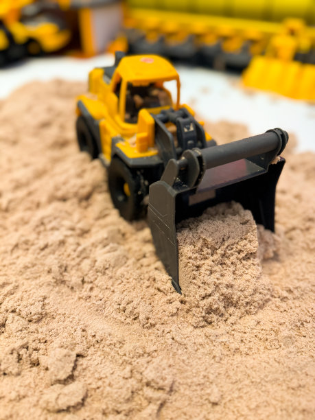 沙子里的儿童黄色拖拉机模型图片下载