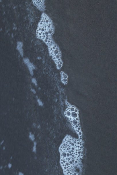 迷人的海洋泡沫:海浪冲击海岸的魔力图片下载