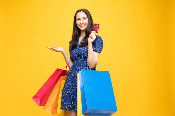 购物的照片欢快的女孩手里拿着彩色的袋子孤立在明亮生动的亮黄色背景股票照片图片下载