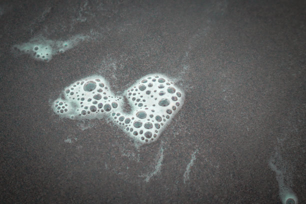 迷人的海洋泡沫:海浪冲击海岸的魔力图片下载