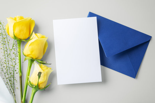 白卡片，蓝信封和米背景上的黄玫瑰，父亲节礼物和卡片图片下载
