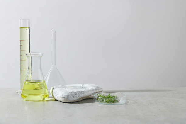 白色背景的照片，在白色桌子的左侧有一套实验室玻璃器皿，旁边是一个空的岩石平台和一个装有绿茶树的培养皿。拷贝空间，前视图图片下载