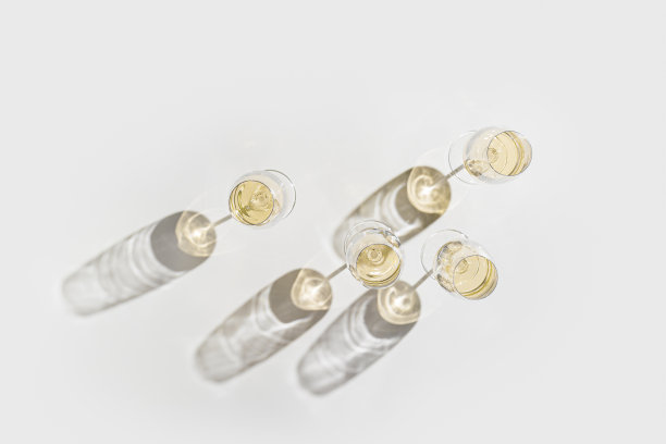 全白酒杯最小的风格以上视图。假日美学静物照片，俯视图闪闪发光的水晶酒杯在自然的阳光下，硬阴影，简单的酒精饮料背景，copyspace图片下载