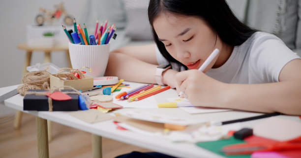 特写照片，年轻女子在家里的客厅里写贺卡。图片下载