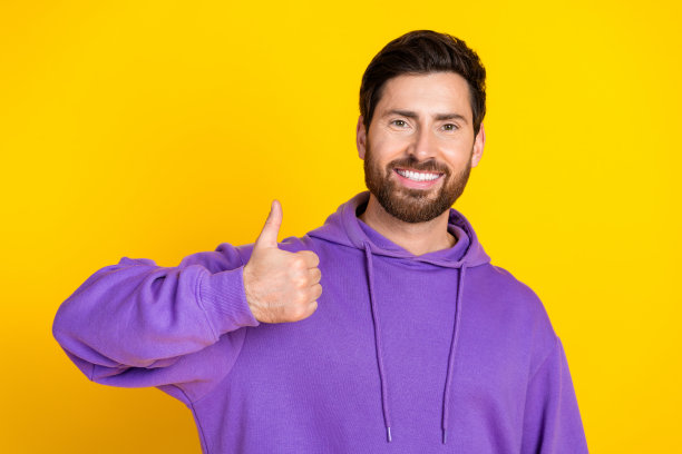 照片满意的男人与时尚的鬃毛穿着紫色卫衣显示拇指向上批准好的工作孤立的黄色背景图片下载