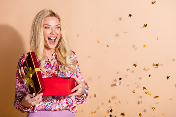 照片中华丽的女士打开礼盒，看起来空无一人，穿的衬衫孤立在米色背景上图片下载