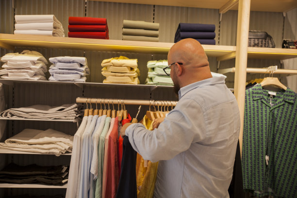 秃顶男子在商店里找衬衫的背影图片下载