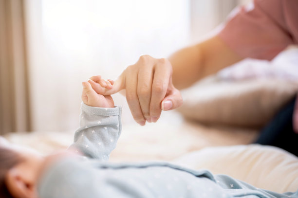 一张特写图片，一个新生儿握着他妈妈的手指。家庭联系图片下载