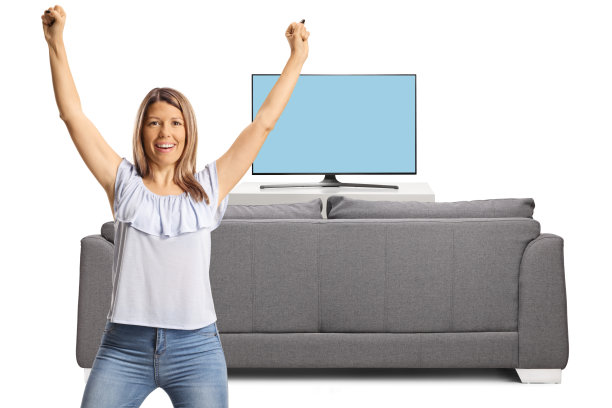 年轻女子在一个有电视和沙发的房间里欢呼图片下载
