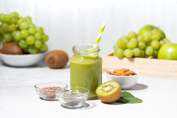 健康的超级食物——由水果和草药制成的绿色奶昔，白色的背景图片下载