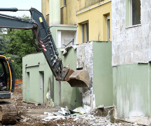 挖掘机用铲斗从立面上拆除隔热覆盖物图片下载