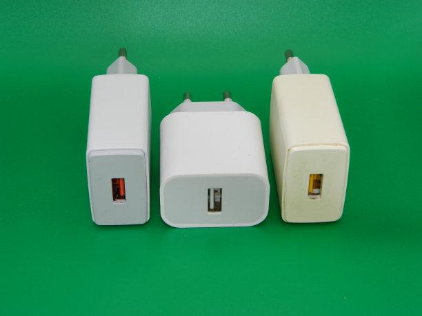 绿色背景下白色充电头的微距照片。通常用于智能手机图片下载