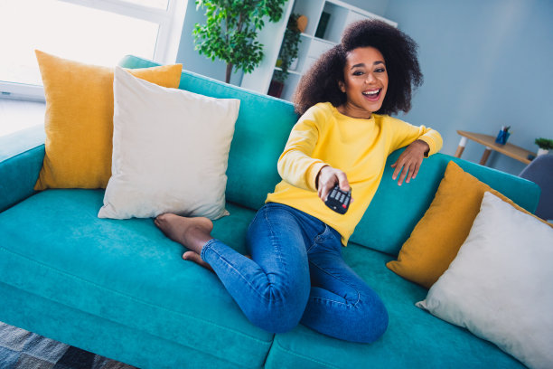 照片开朗可爱可爱的女孩坐在沙发上看电影周末在舒适的公寓日光室内图片下载