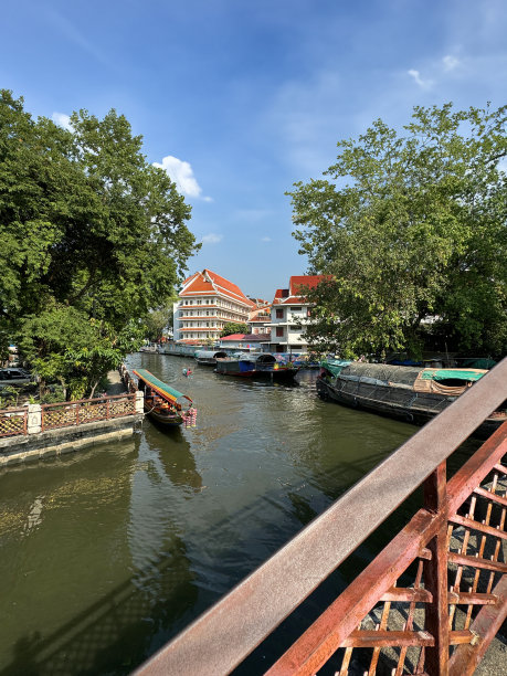 从装饰华丽的阶梯桥上俯瞰的图片，上面有带顶篷的木制游船载着游客游览Khlong Damnoen Saduak运河附近，游船行驶在通往Tha Chin和Mae Klong河的水路上图片下载